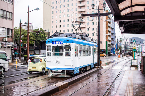 Nagasaki, Japan - 2 November 2020: Blue and white tram on a rainy day in Nagasaki