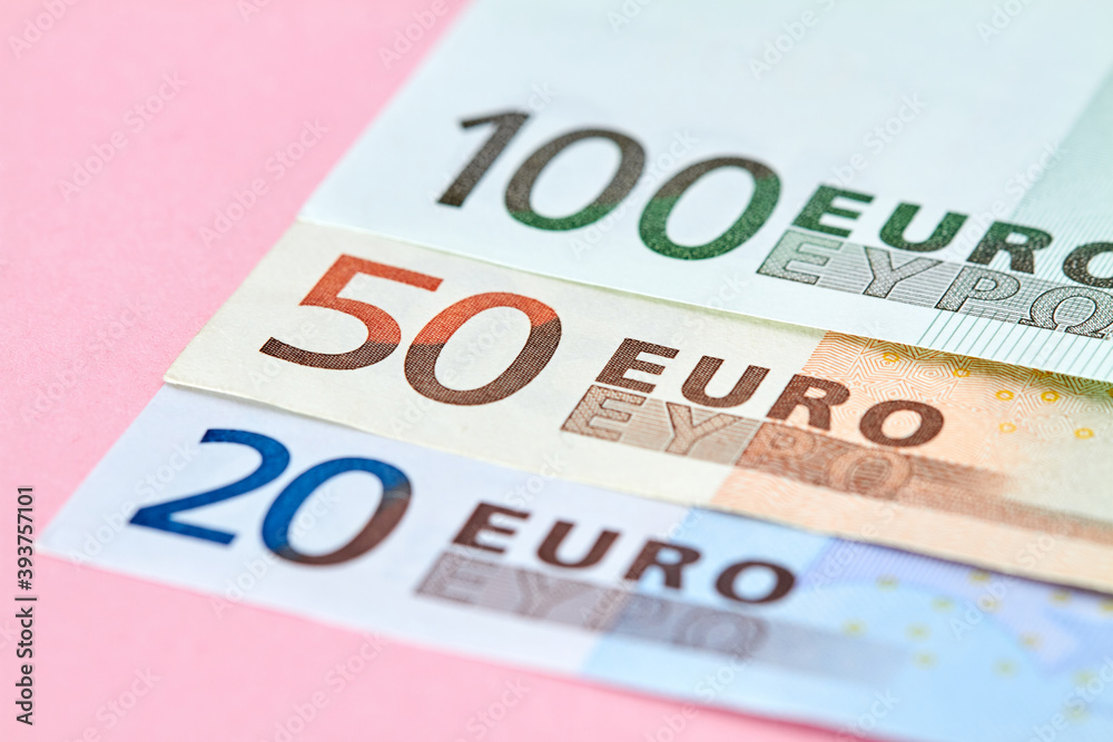20, 50, 100 Euro banknotes on pink background. Close-up, selective focus 20, 50, 100 Euro banknotes on pink background. Close-up, selective focus