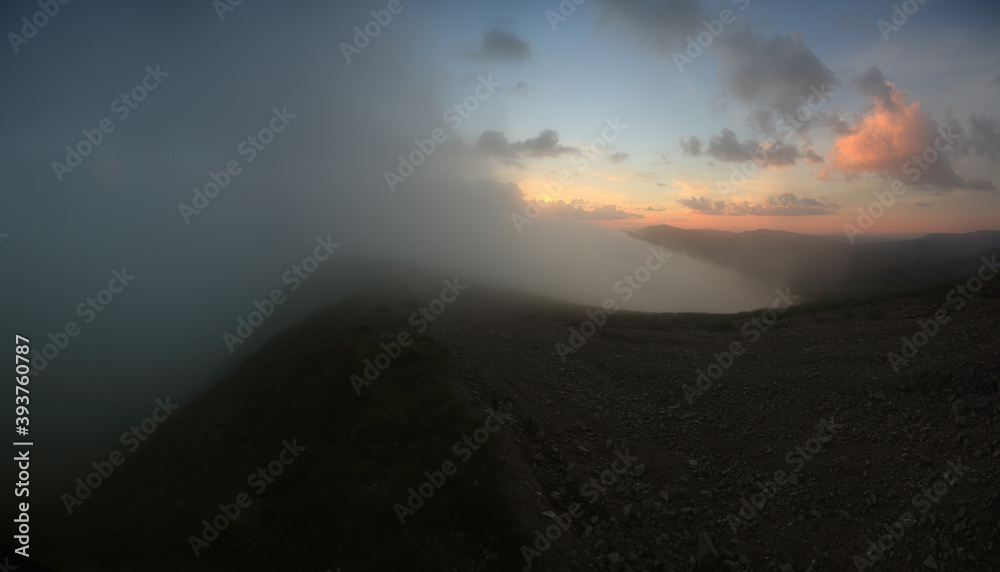 Panoramic view of the clouds high in the mountains on the mountain pass.