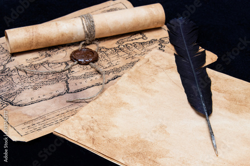 An ancient paper scroll sealed with a seal. Old map. Blank sheet of paper, pen for writing.