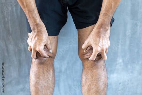 young man knee ache on against a gray background