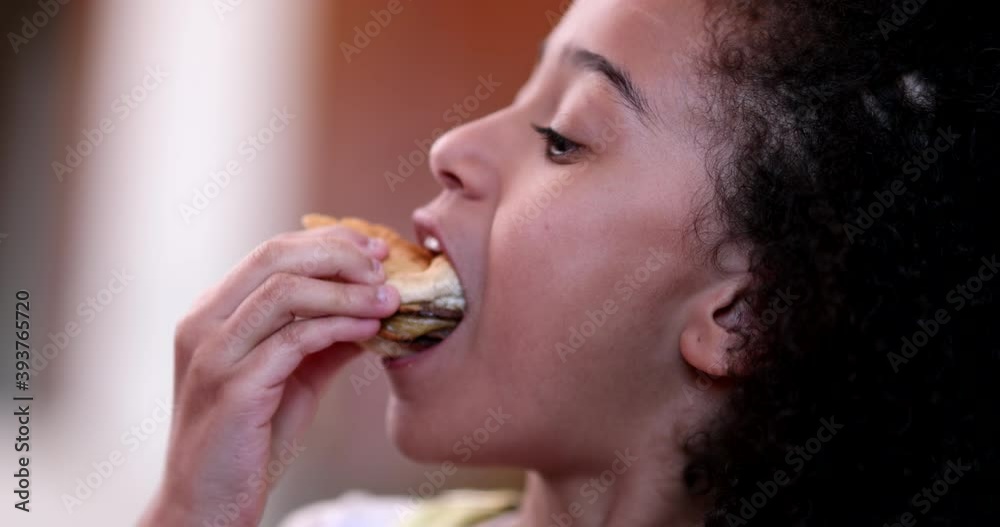 Little girl eating burger. Child taking a bite of hamburger Little girl eating burger. Child taking a bite of hamburger