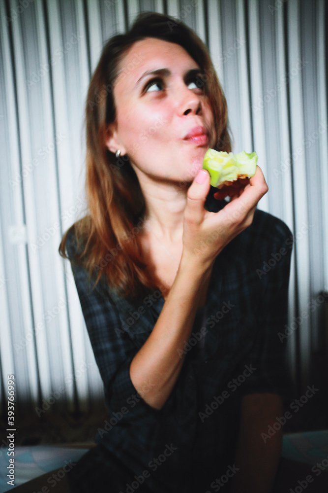 Young caucasian woman eating a green apple at home Young caucasian woman eating a green apple at home