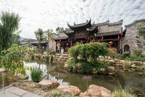 Traditional Chinese garden, a tourist attraction at Wolong College in Changting city, with ancient wood buildings, stones, and small lake photo