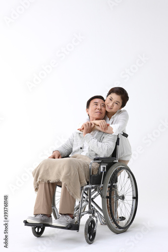 휠체어를 탄 남성과 여성 간병인