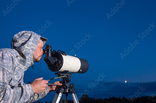 Foto A male astronomer observes the sky through a telescope