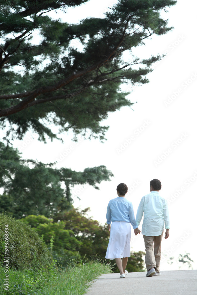 Fototapeta premium 공원에서 손을잡고 산책하는 커플