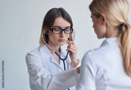 Professional doctor woman with stethoscope and heartbeat health patient light background