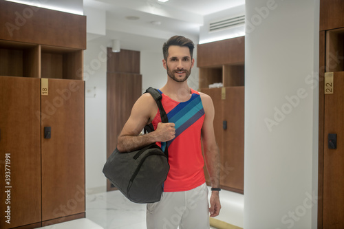 Sporty young man in bright tshirt staning in changing room