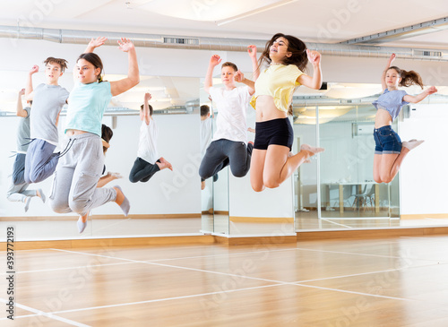 Group of young dancers jumping together in dance class