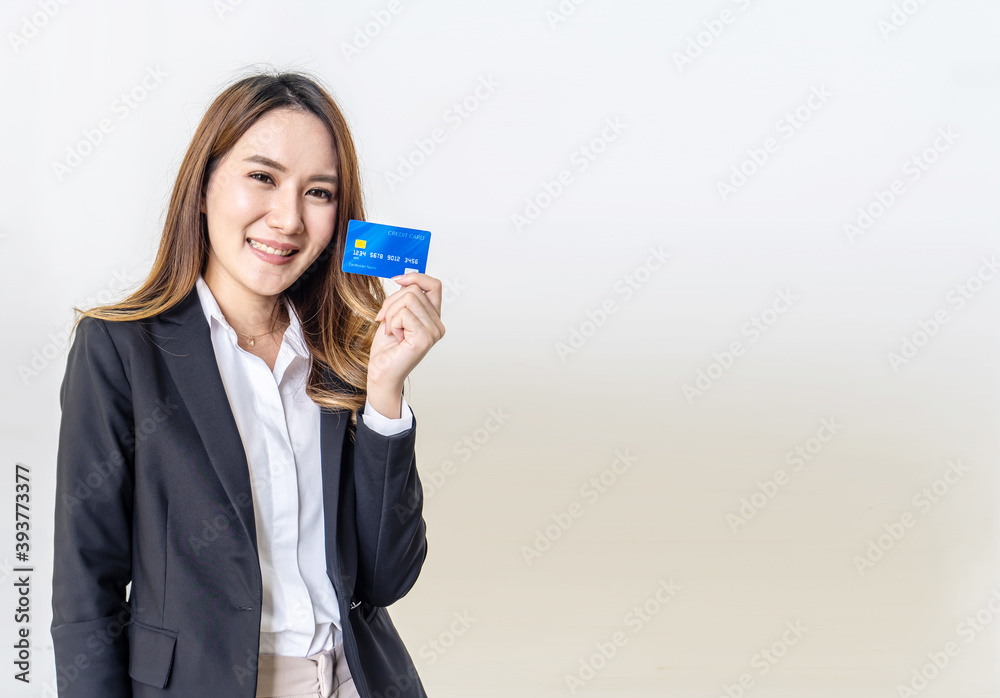 Smiling business Asian woman presenting credit card in hand showing trust and confidence for making payment isolated on a white background Smiling business Asian woman presenting credit card in hand showing trust and confidence for making payment isolated on a white background