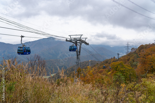 View of mountains and valleys from the Dragondola (Naeba-Tashiro Gondola) in autumn foliage season. Longest aerial gondola lift line in Japan. Naeba, Yuzawa, Niigata Prefecture, Japan.