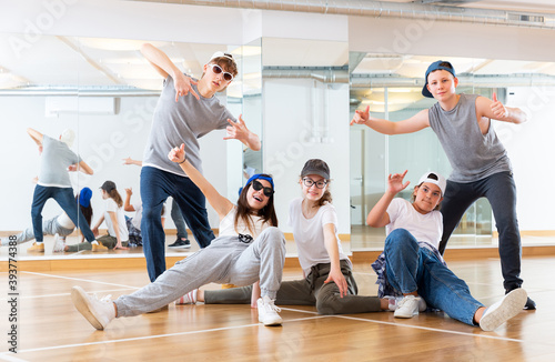 Portrait of cheerful teenage girls and boys hip hop dancers posing during group dance workout