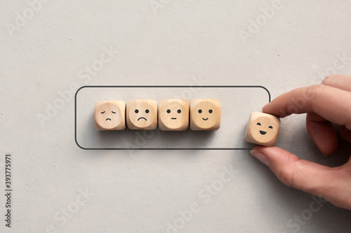 Wooden cubes with drawings of various emotions show the battery loading