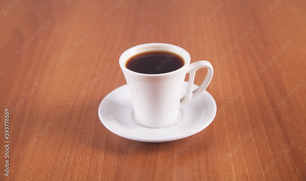 Coffee in a white cup is isolated on a wooden background. Coffee in a white cup is isolated on a wooden background.
