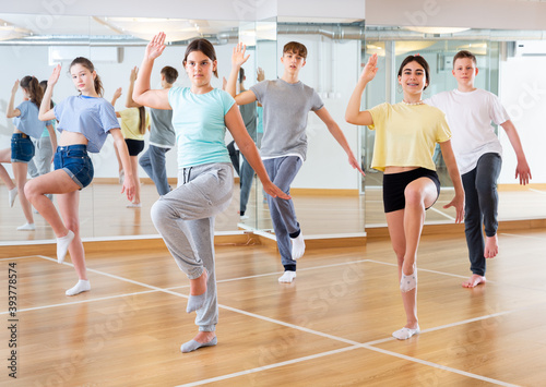 Dancing group of five teenagers practicing new dance in studio