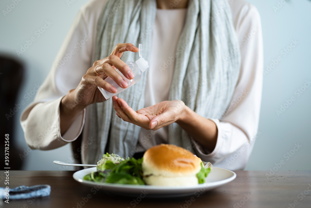食事前に手を消毒する女性 食事前に手を消毒する女性