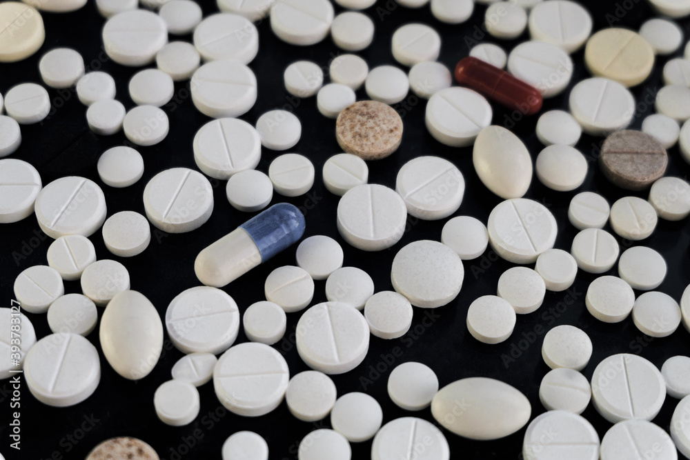 Medication and pills on a black surface. Limeted depth of field.
