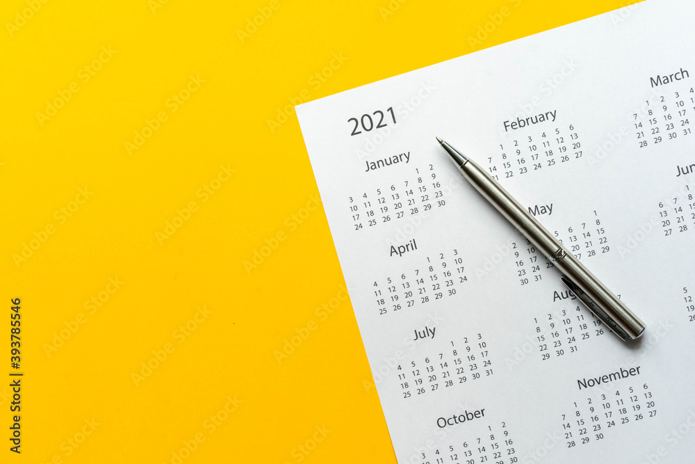 close up top view on white calendar 2021 schedule with pen on yellow color  background to make appointment meeting or manage timetable each day for  design planning work and life concept Stock