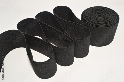 Black Rubber elastic band. Cloth ribbon made of polyester fibre for the production of knitwear textile tapes. photo