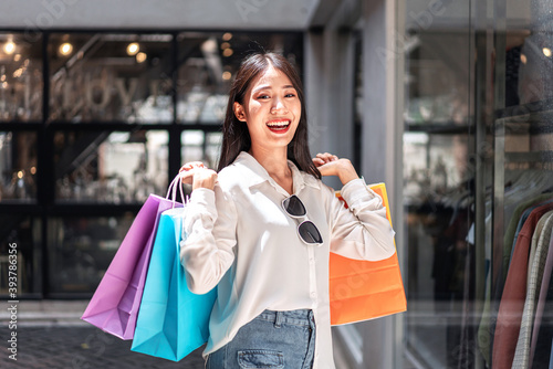 Portrait of Asian girl excited beautiful girl happy smiling with holding shopping bags relaxed expression, Positive emotions shopping, lifestyle concept