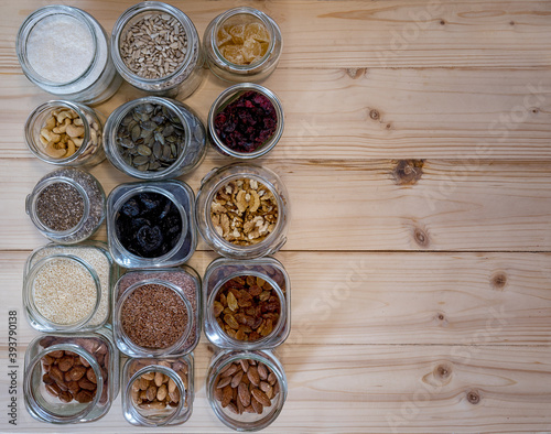 Seed,nut and dried fruits in various jars over wood background. 