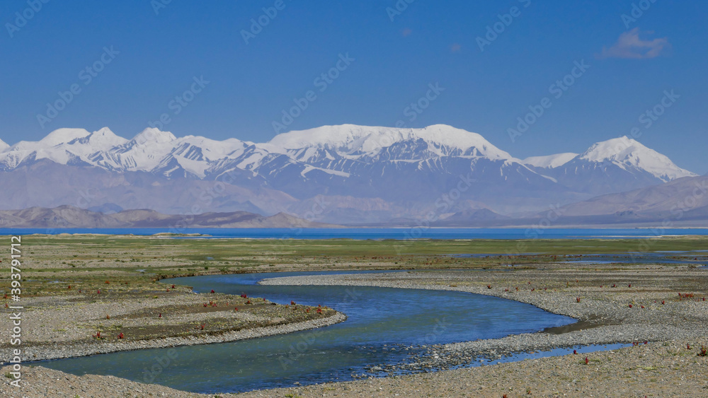 Snow-capped mountains with river foreground around Karakul lake, Murghab district, Gorno-Badakshan, in the Pamir region of Tajikistan Snow-capped mountains with river foreground around Karakul lake, Murghab district, Gorno-Badakshan, in the Pamir region of Tajikistan