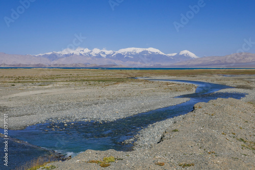 View from the shores of Karakul lake after sunrise, with Zulumart snow-capped mountain range and river in foreground, Murghab district, Gorno-Badakshan, in the Pamir region of Tajikistan © Cyril Redor