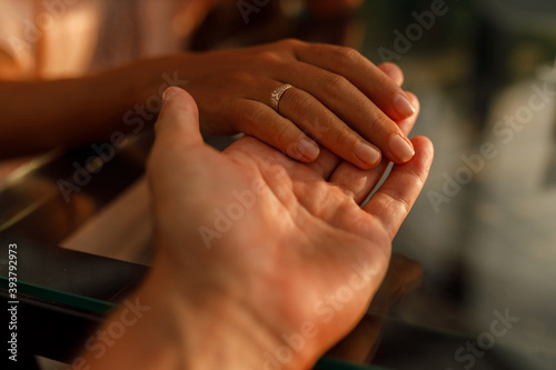  Romantic couple holding each other's hand at dinner in a luxury restaurant. Marriage proposal and engagement concept. © Yevhenii