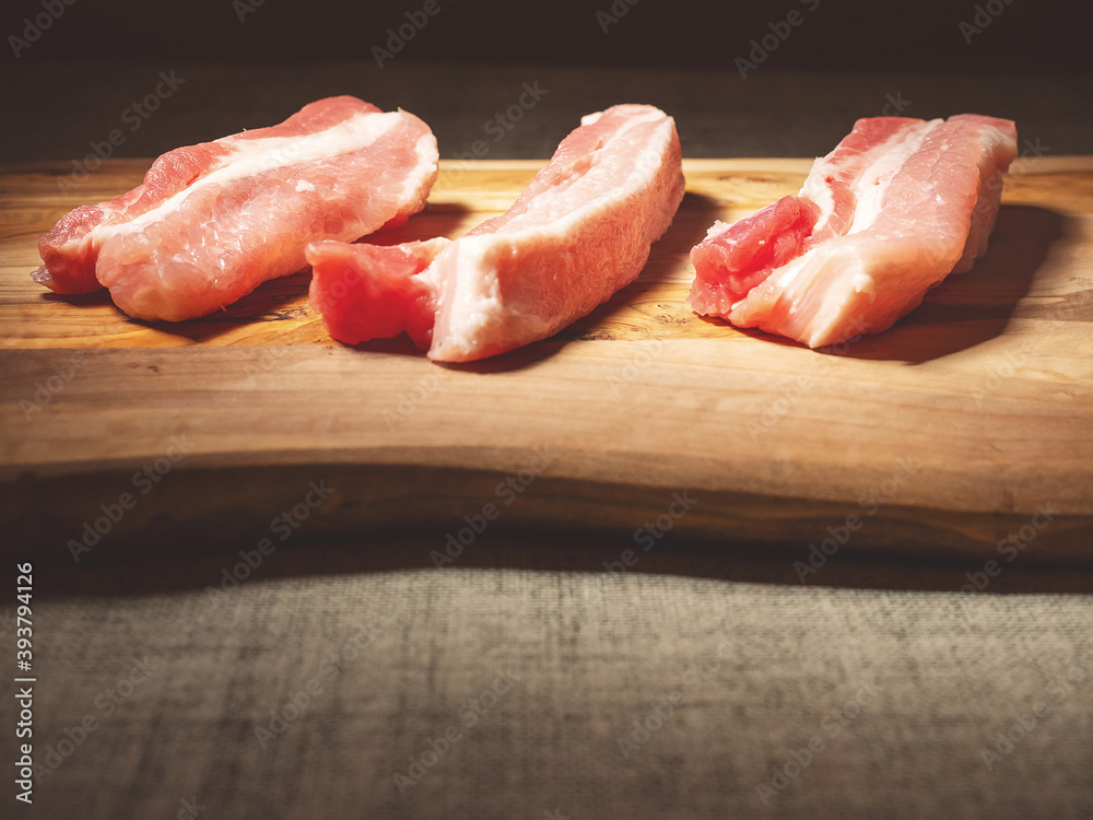 Three fresh uncooked pork belly portions on a wooden cutting board. Meat industry product Three fresh uncooked pork belly portions on a wooden cutting board. Meat industry product