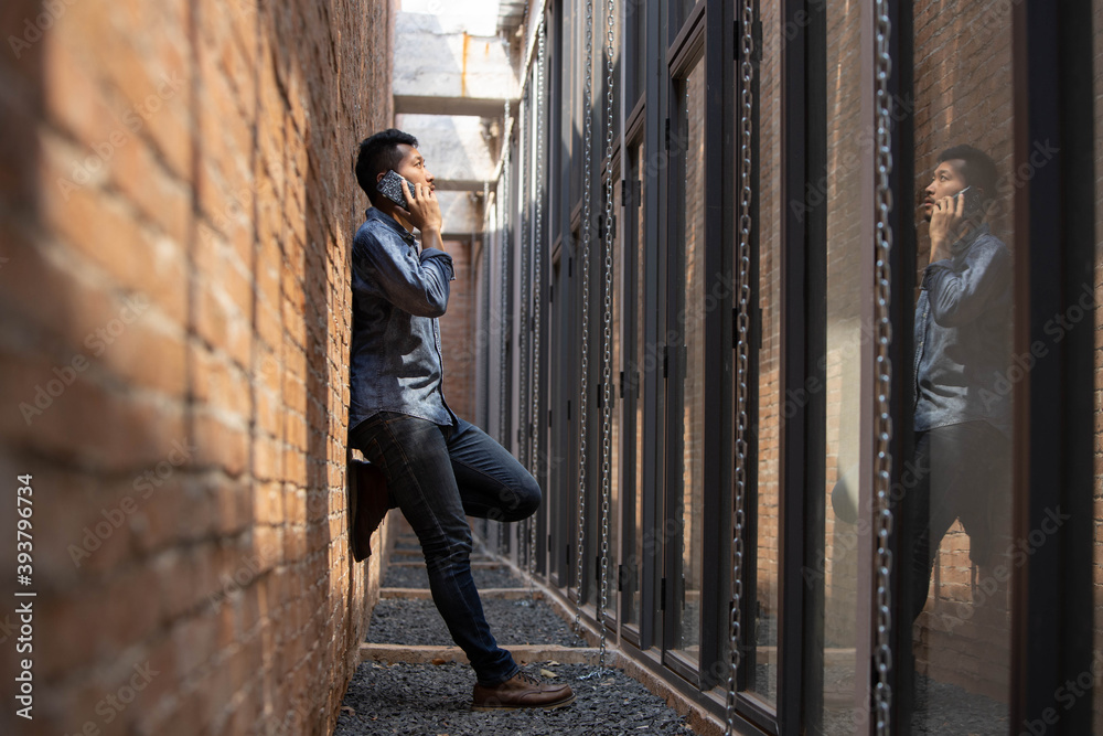 business man talking on the phone beside the modern wall business man talking on the phone beside the modern wall