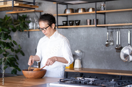 キッチンで料理を作る中高年男性 