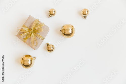 Christmas flat lay with craft gift box and golden Christmas balls on the white background. Christmas decoration. Winter, New Year and Christmas concept
