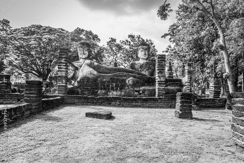 Fototapeta premium Landmark of Buddha image made of ancient bricks in the Kamphaeng Phet Historical Park, Thailand. Black and white
