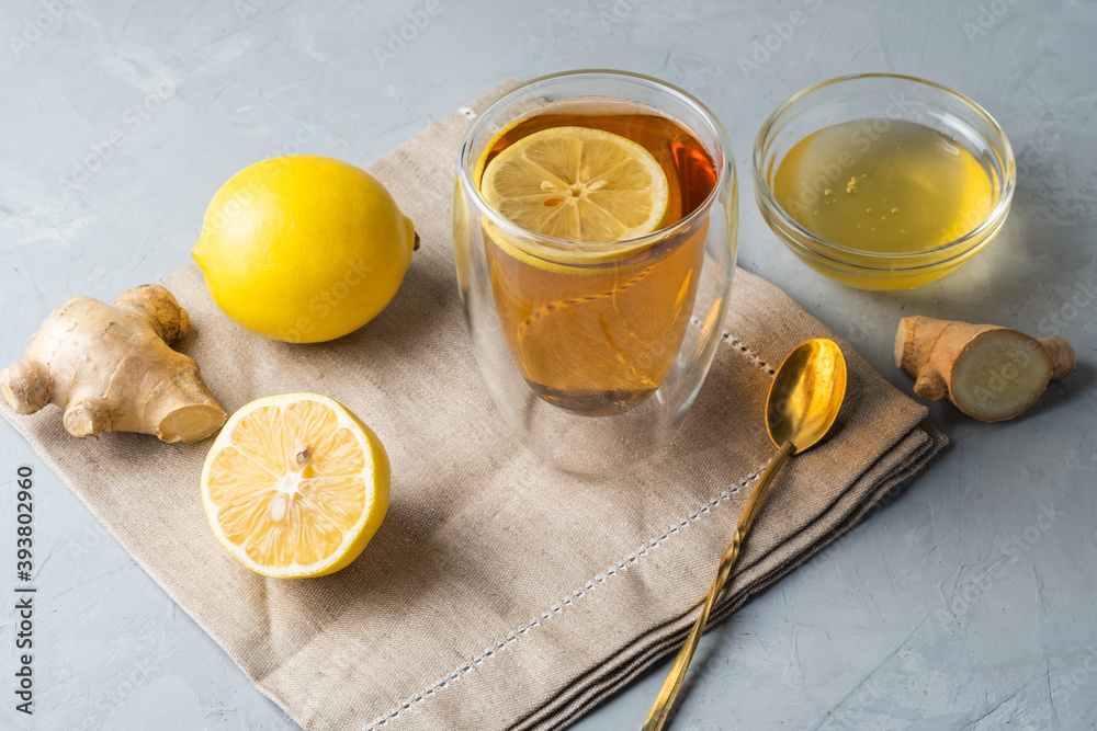 Healthy living herbal tea; lemon honey tea with ginger root on a gray background Healthy living herbal tea; lemon honey tea with ginger root on a gray background