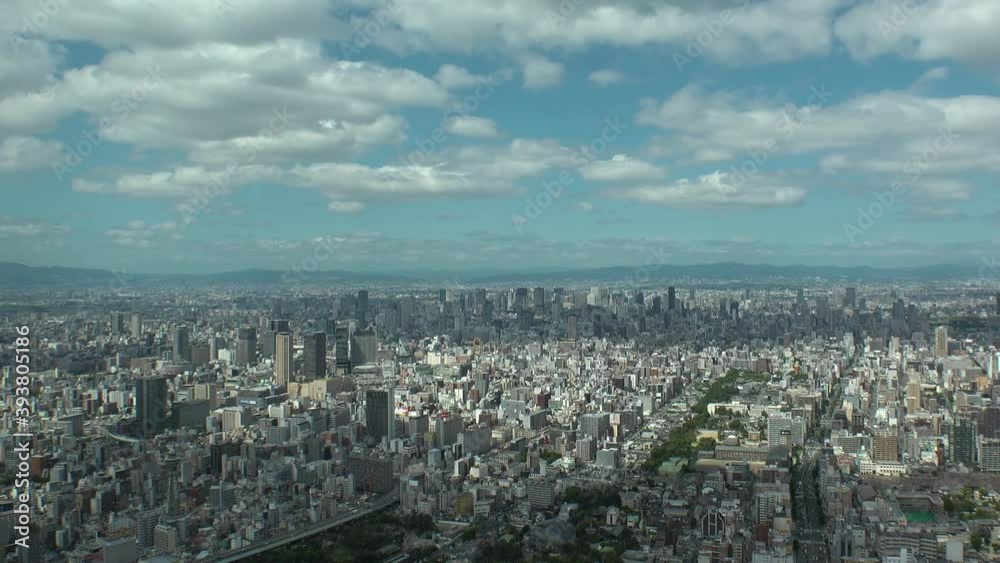 OSAKA, JAPAN : Aerial high angle view of CITYSCAPE of OSAKA in day time. View of buildings and streets around Namba, Shinsaibashi, Umeda and Osaka train station. Wide view time lapse tracking shot. OSAKA, JAPAN : Aerial high angle view of CITYSCAPE of OSAKA in day time. View of buildings and streets around Namba, Shinsaibashi, Umeda and Osaka train station. Wide view time lapse tracking shot.