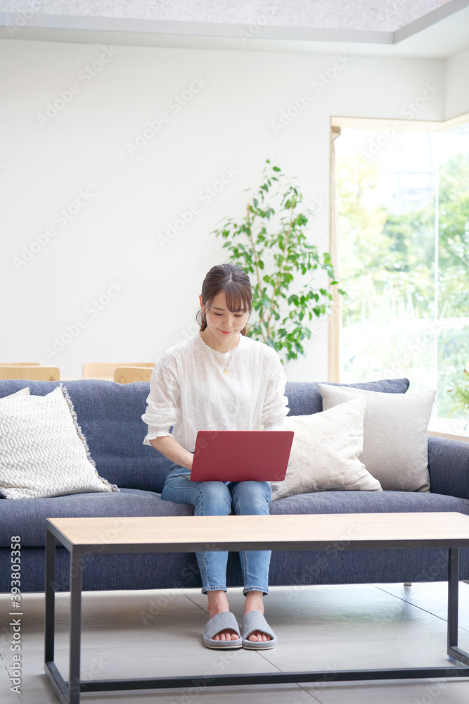 リビングでパソコンを使う女性 リビングでパソコンを使う女性