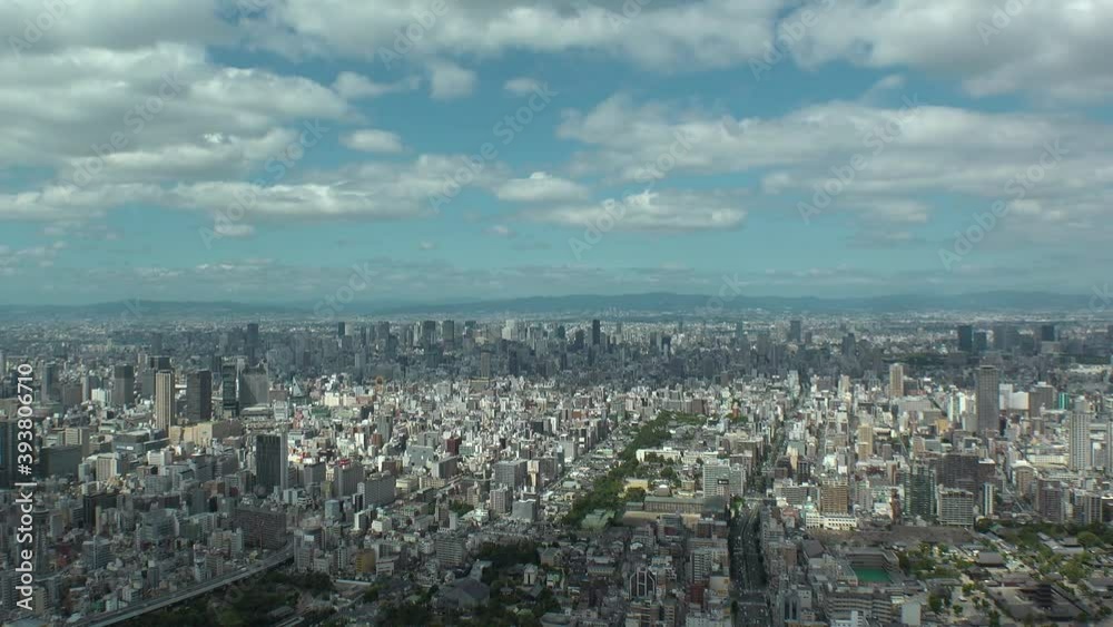 OSAKA, JAPAN : Aerial high angle view of CITYSCAPE of OSAKA in day time. View of buildings and streets around Namba, Shinsaibashi, Umeda and Osaka train station. Wide view time lapse tracking shot. OSAKA, JAPAN : Aerial high angle view of CITYSCAPE of OSAKA in day time. View of buildings and streets around Namba, Shinsaibashi, Umeda and Osaka train station. Wide view time lapse tracking shot.