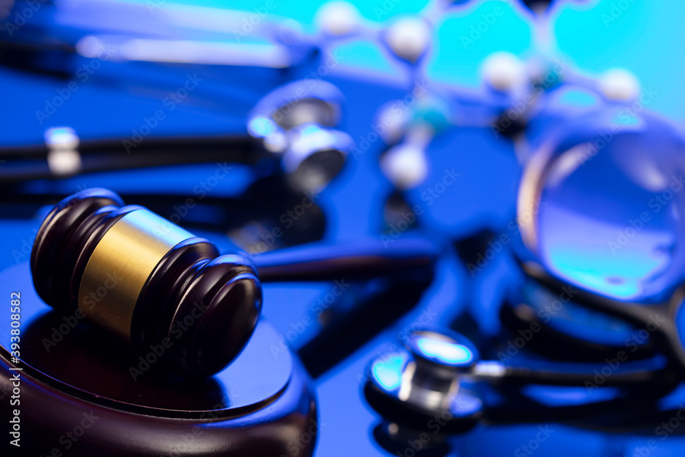 Medical law concept. Gavel and stethoscope on the glass table. Blue light. Medical law concept. Gavel and stethoscope on the glass table. Blue light.