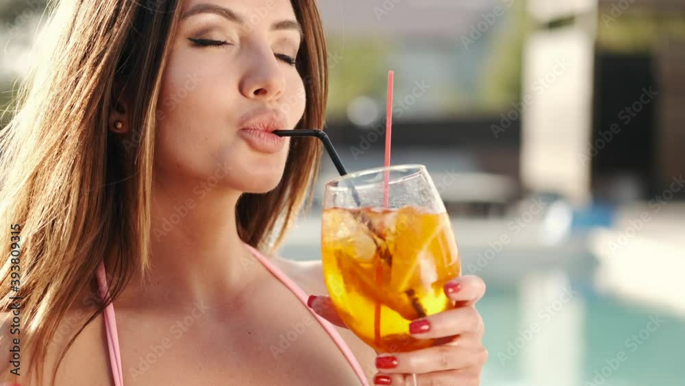 Portrait of sexy girl with cocktail by the pool. Slow motion Portrait of sexy girl with cocktail by the pool. Slow motion