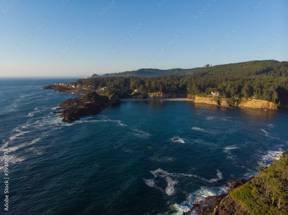 Aerial view of forest rocky coast and blue ocean waves at warm sunny day. Fantastic nature. Travel and discover concept. Wallpaper design.
