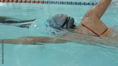 Young professional swimmer training front crawl technique for swimming competition and do flip turn. Slow motion video. 