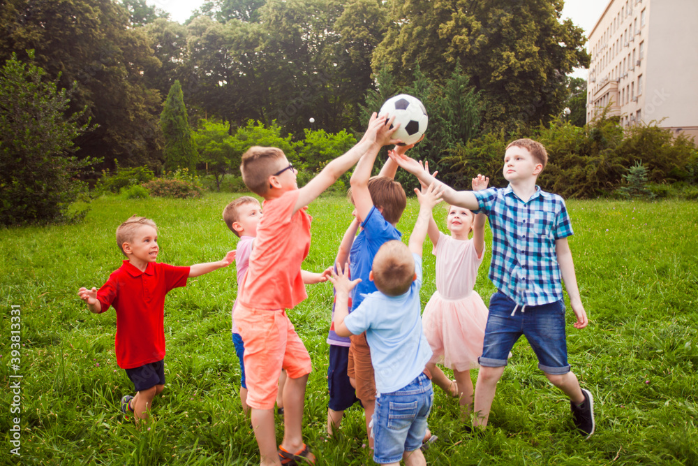 Fototapeta premium The kids play with a ball in the school garden