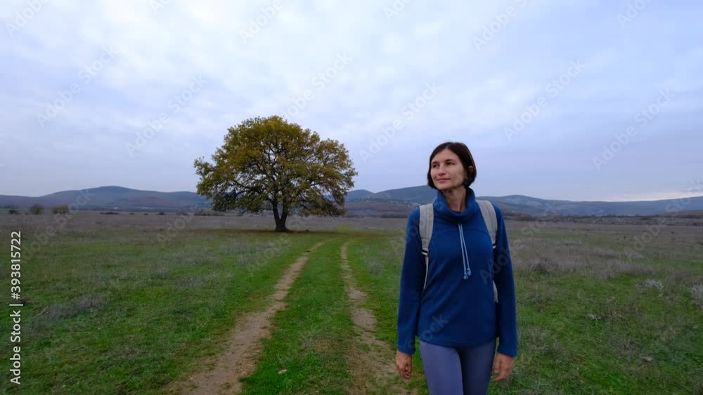Woman walking a dirt road with an oak tree. Independent asian woman with soft natural lighting. Woman walking a dirt road with an oak tree. Independent asian woman with soft natural lighting.