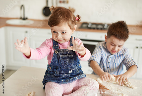 Boy and girl littered in flour in the kitchen photo