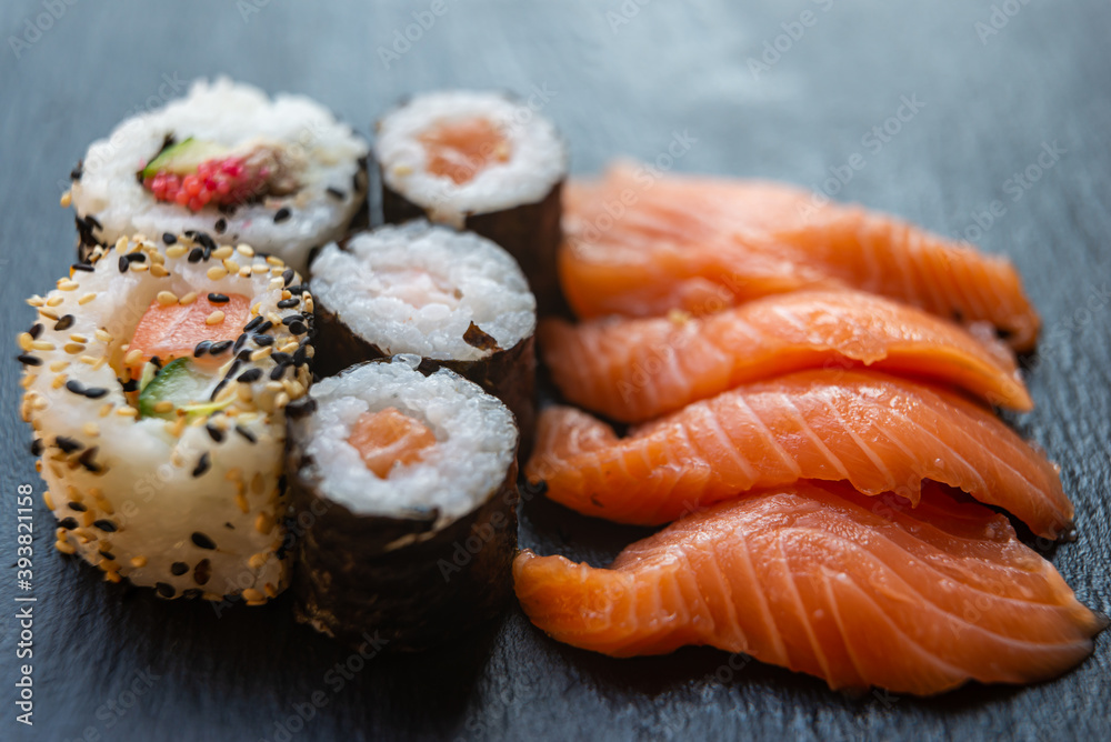Sushi, uramaki, rolls and sashimi on a slate tray. Sushi, uramaki, rolls and sashimi on a slate tray.