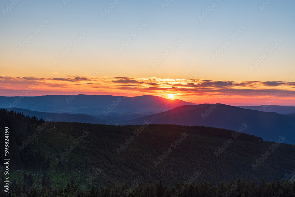 Sunset with colorful sky from Dlouhe strane hill in Jeseniky mountains in Czech republic