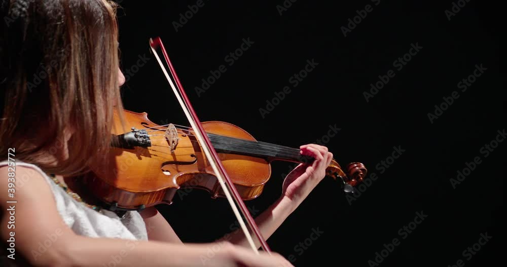 Professional violinist playing the violin, female musician playing the violin, on a black background, 4k video