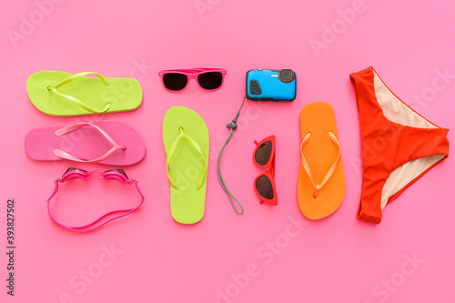 Set of beach accessories with flip-flops on color background. Concept of family vacation