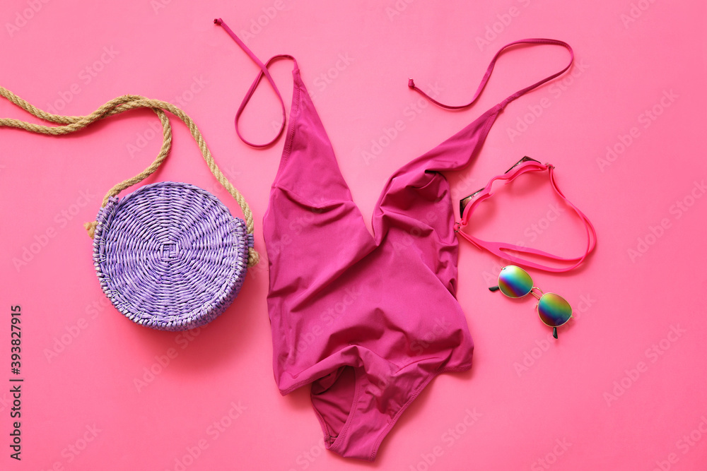 Set of beach accessories with female swimsuit on color background
